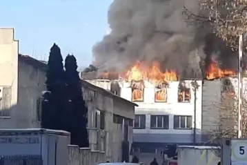 Пожежа на даху білої офісної будівлі з полум’ям і густим димом