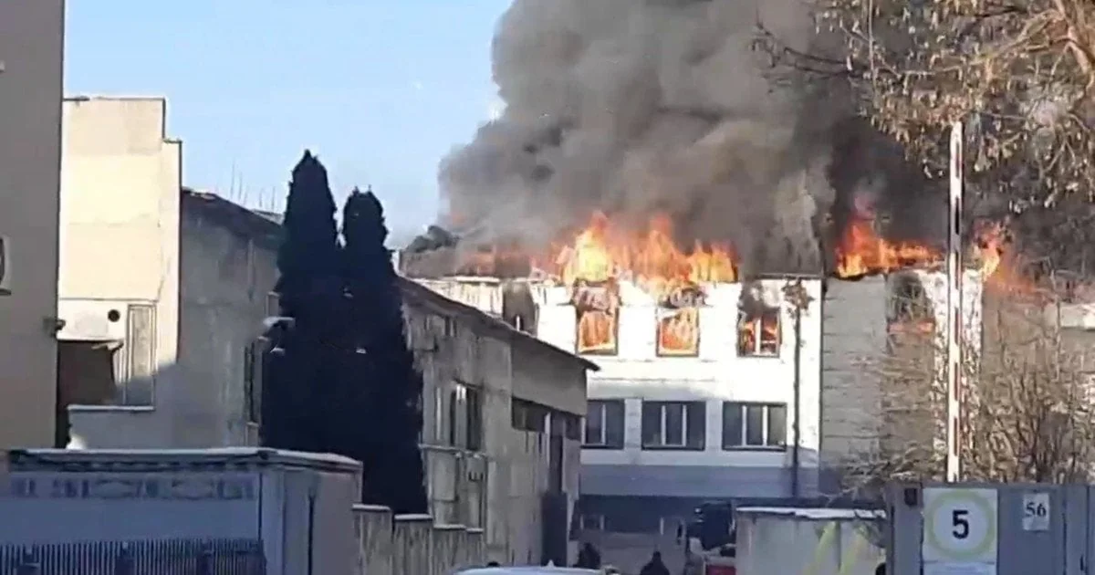 Пожежа на даху білої офісної будівлі з полум’ям і густим димом