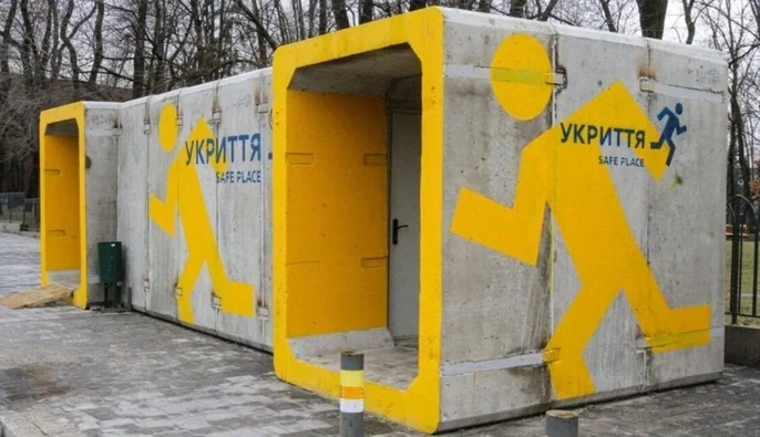 Бетонні модульні укриття з жовтими піктограмами людини та написом УКРИТТЯ